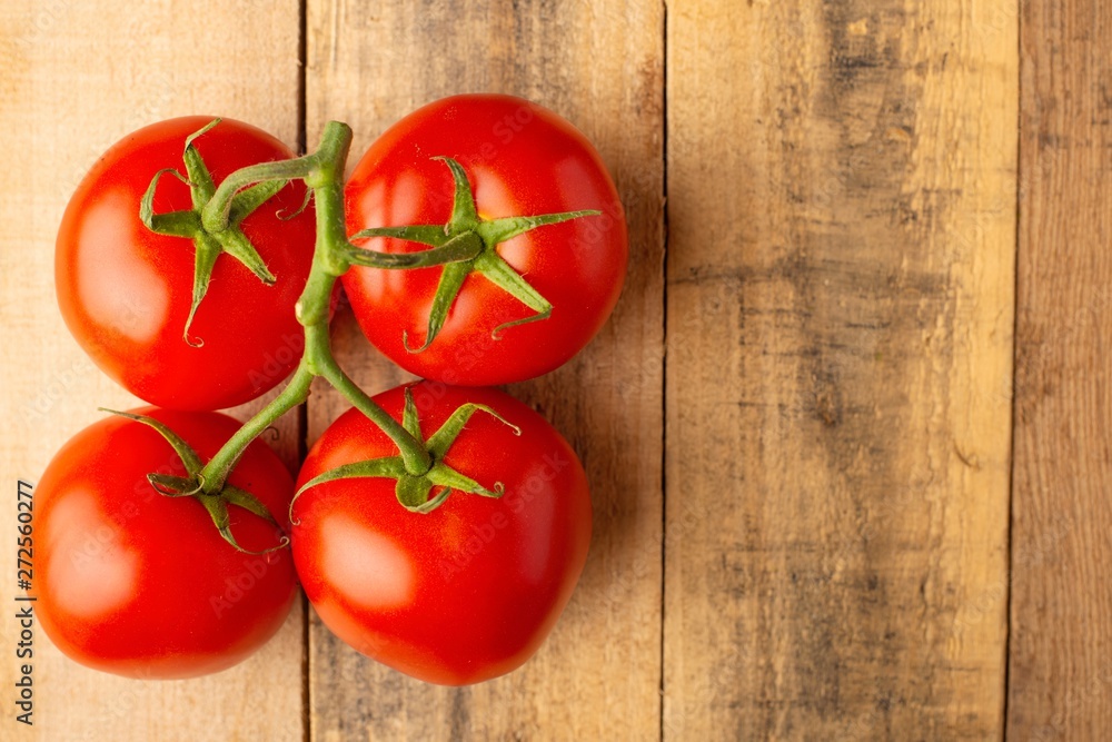 Fresh twig with red tomatoes on a wooden background. harvesting. rural area. fresh vegetables Fresh twig with red tomatoes on a wooden background. harvesting. rural area. fresh vegetables