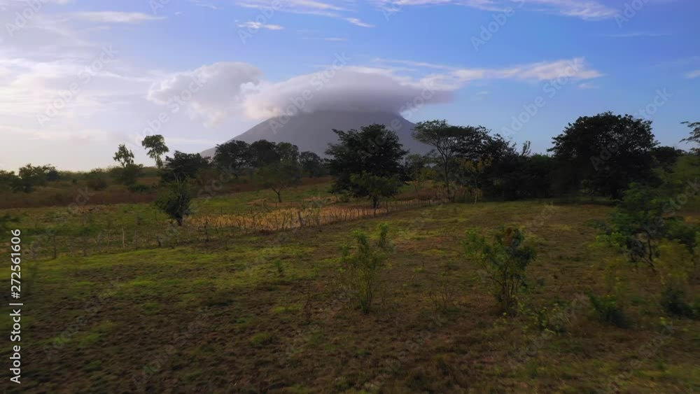 Aerial Forward/Ascend: Volcano In Green Valley With Smoke Above  - Ometepe, Nicaragua
