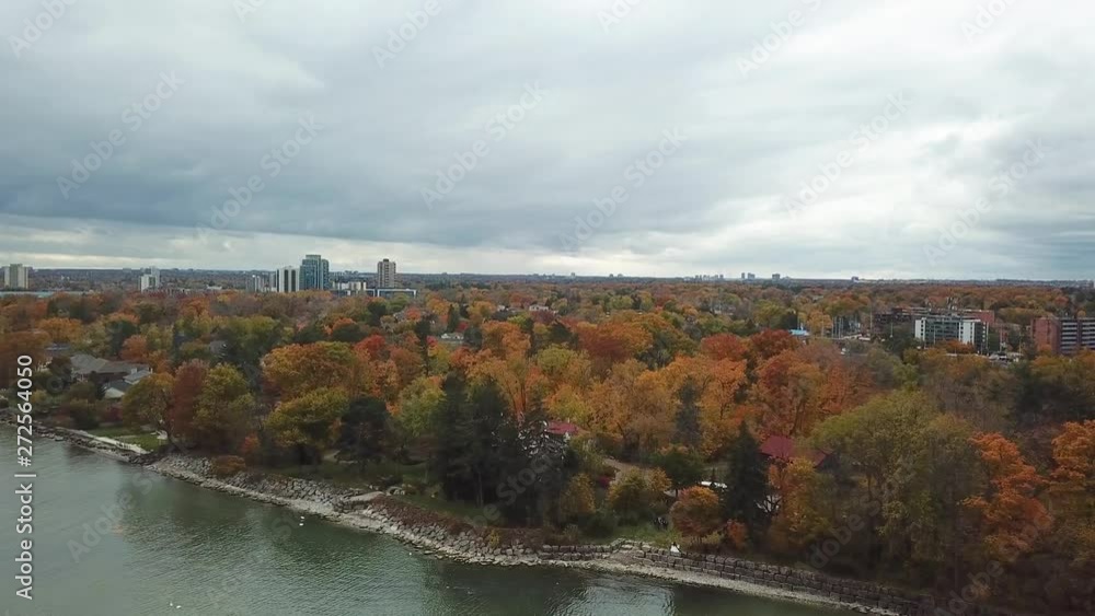 Drone shot of City of Vaughan, Ontario, Skyline from Lake with Autumn Leaves and Park Trees and Overcast Sky Drone shot of City of Vaughan, Ontario, Skyline from Lake with Autumn Leaves and Park Trees and Overcast Sky