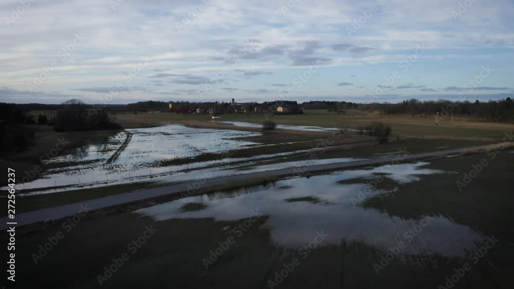 Aerial shot of flooded fields close to suburban buildings Aerial shot of flooded fields close to suburban buildings