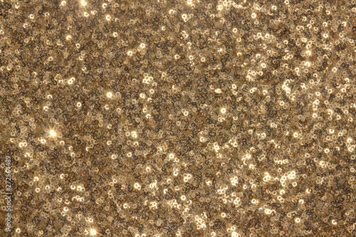 Texture of fabric with little round  golden sequins. Shiny abstract fashion texture. Similarity of fish scales.
