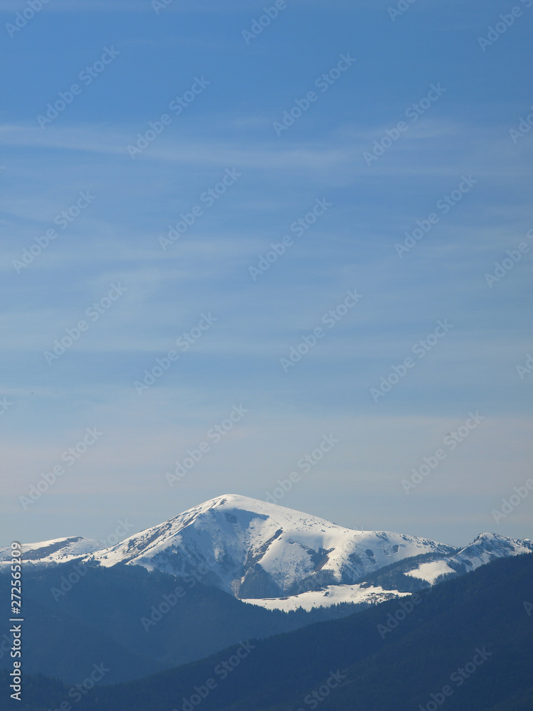 Morning landscape with mountains and blue sky. Evening sunset on the horizon of hills with white snow and cloud