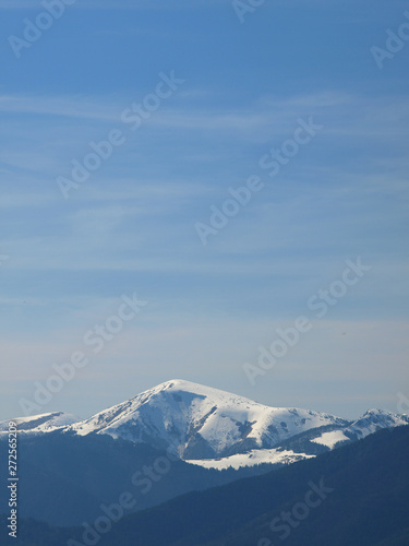 Morning landscape with mountains and blue sky. Evening sunset on the horizon of hills with white snow and cloud © lacodk