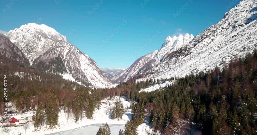Lago del Predil, Tarvisio / Italy a frozen alpine lake in a snow-covered winter fairytale mountain landscape. People Ice skating on a frozen lake in Italy Lago del Predil, Tarvisio / Italy a frozen alpine lake in a snow-covered winter fairytale mountain landscape. People Ice skating on a frozen lake in Italy
