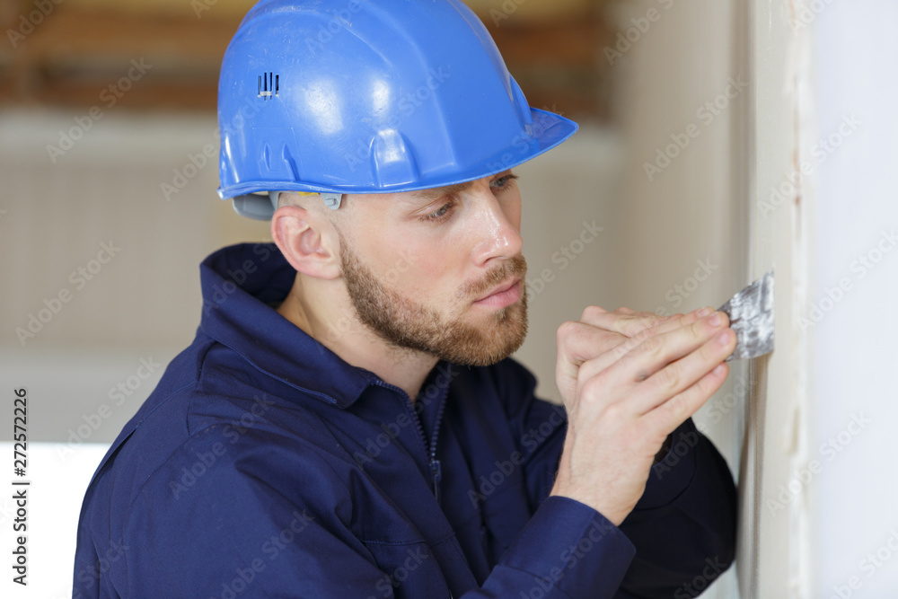 worker filling a wall with putty worker filling a wall with putty