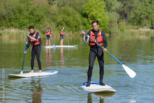 Valokuva group of people on paddle boards on a lake