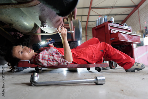 Photos female mechanic underneath a car