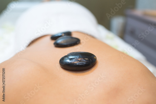 hot stones on a womans back at spa salon
