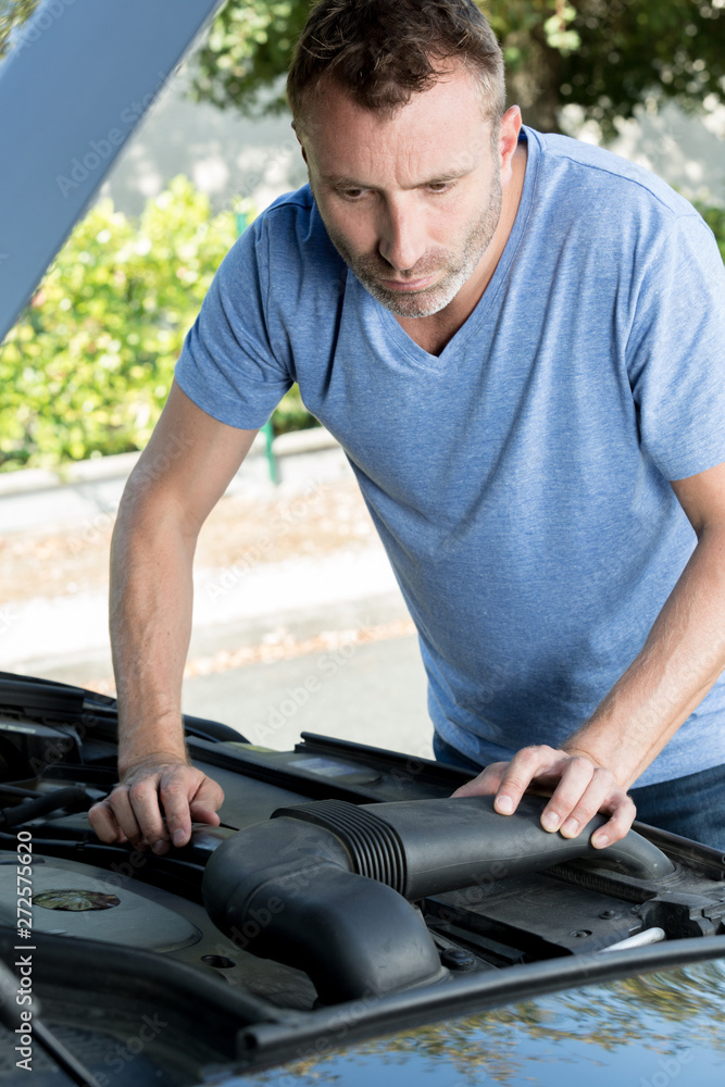 man checking under the car bonnet man checking under the car bonnet