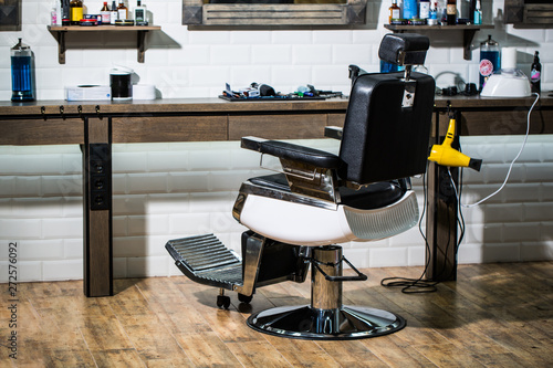 Professional hairstylist in barbershop interior. Barber shop chair. Barbershop armchair, modern hairdresser and hair salon, barber shop for men. Beard, bearded man. Stylish vintage barber chair.