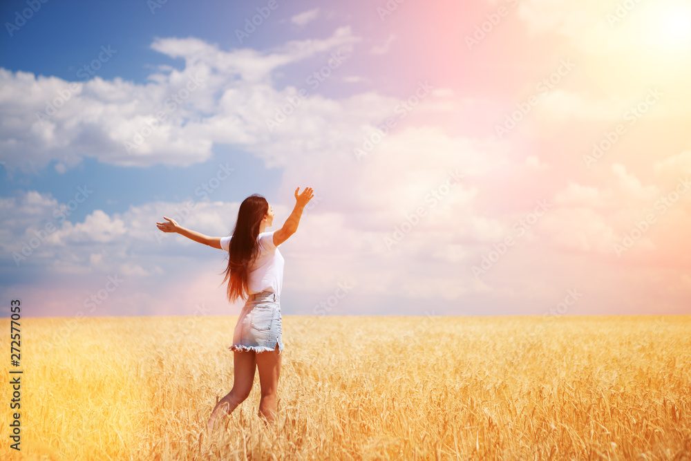 Happy woman enjoying the life in the field Nature beauty, blue sky and field with golden wheat. Outdoor lifestyle. Freedom concept. Woman jump in summer field Happy woman enjoying the life in the field Nature beauty, blue sky and field with golden wheat. Outdoor lifestyle. Freedom concept. Woman jump in summer field