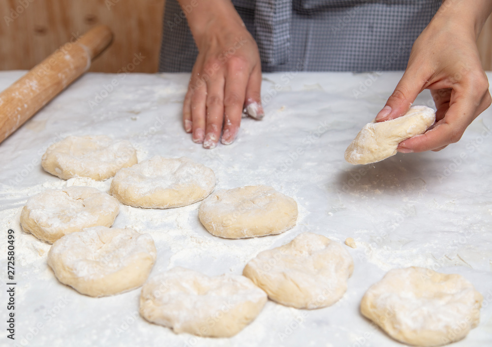 Girl rolls the dough in the kitchen Girl rolls the dough in the kitchen