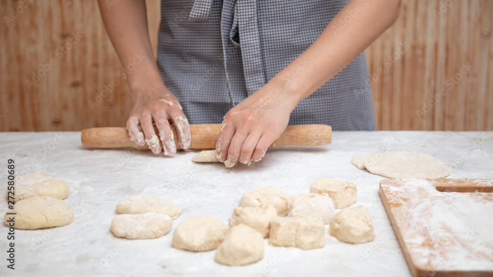 Girl rolls the dough in the kitchen Girl rolls the dough in the kitchen
