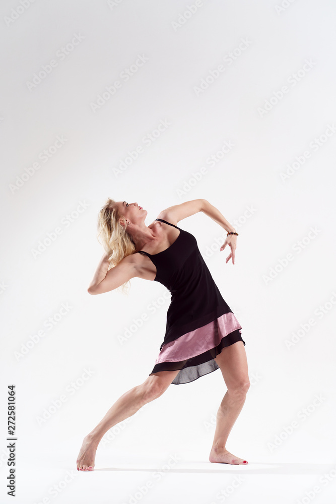 Photo of dancing woman looking away in short black dress Photo of dancing woman looking away in short black dress