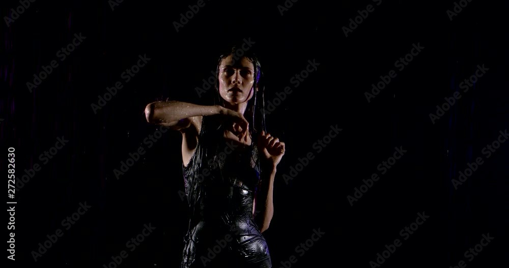 tempting young woman is getting wet under rain in night time, stretching hand up tempting young woman is getting wet under rain in night time, stretching hand up