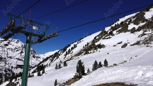 Panorama horizontal. Many people start skiing on a well-groomed ski slope at a ski resort. The sun is shining and the sky is bright and clear photo