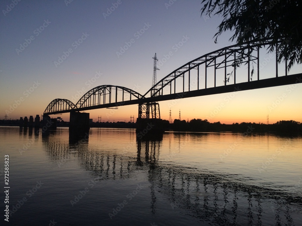 old military bridge over river at sunset