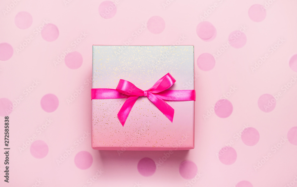 Pink present box on pink konfetti background. Top view, flat lay. Holiday gift concept. Pink present box on pink konfetti background. Top view, flat lay. Holiday gift concept.