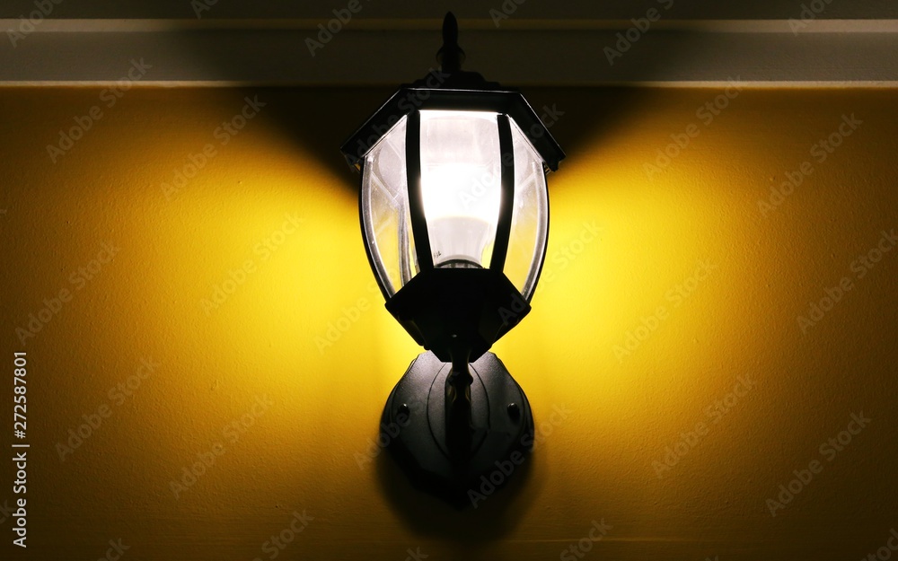 Electric lighting lamp on yellow wall closeup interior