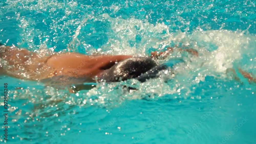 Boy swims in the style of crawl in the pool. Boy swims in the style of crawl in the pool.