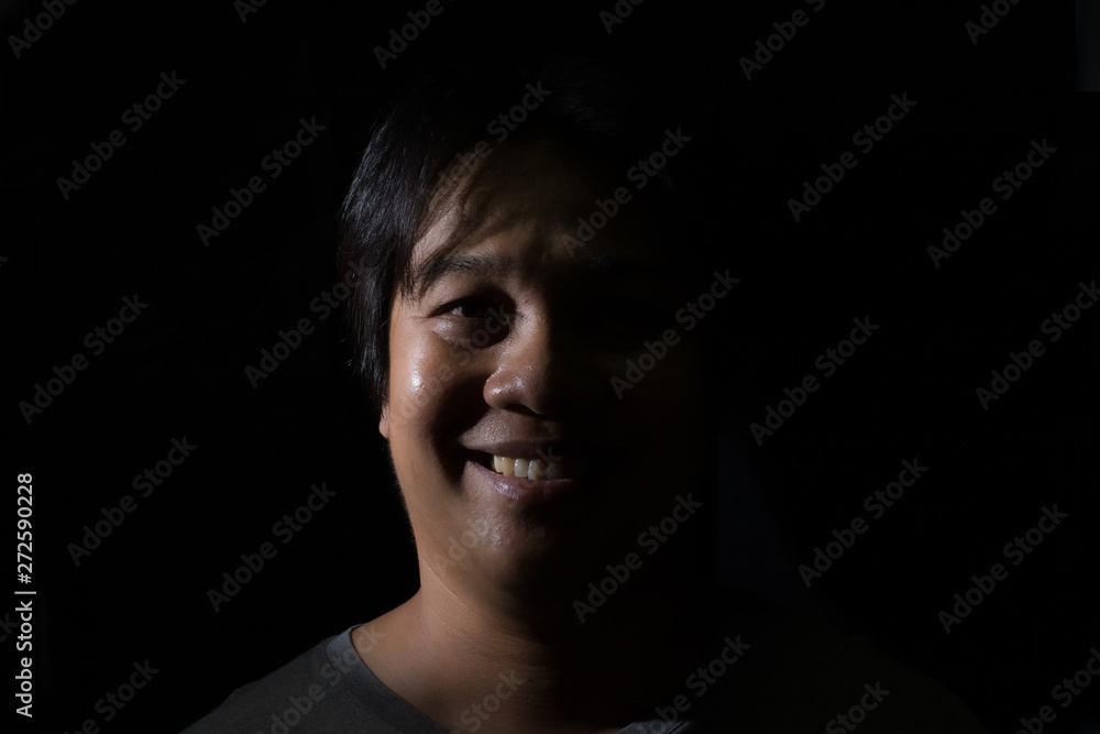 Portrait of a men smiling with in studio black background