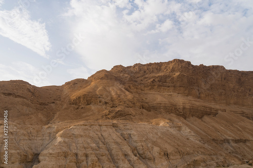 Dusty, dry view of the arid Judean Desert of Israel, at the west bank of the Jordan river. Droughty area and terracotta cliff against the scyscape. Close up of lifeless rocks. Wastelands photo