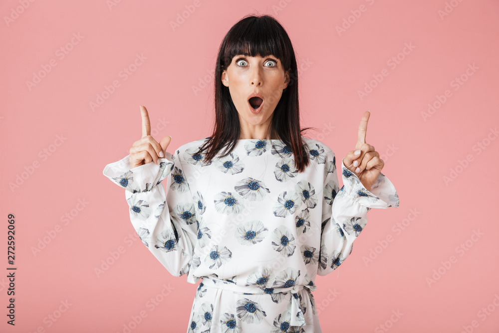 Shocked young woman posing isolated over pink wall background pointing. Shocked young woman posing isolated over pink wall background pointing.