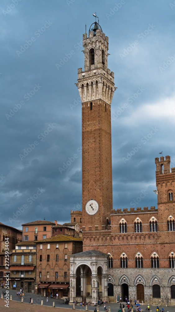 Torre del Mangia, clock tower of a city hall on Piazza del Campo main square in Siena, Tuscany, Italy