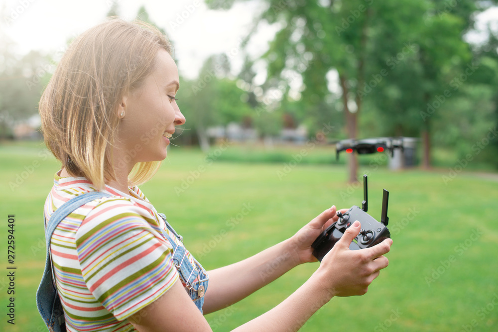 The girl drives a quadrocopter in the park. Flights in the park. Fun spending time