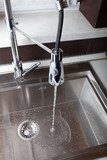 Flow of water in a metal sink on a modern kitchen