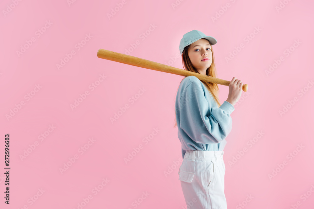 pretty teenage girl in cap holding wooden baseball bat isolated on pink pretty teenage girl in cap holding wooden baseball bat isolated on pink