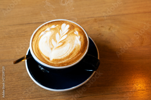 Hot latte on a wooden dining table