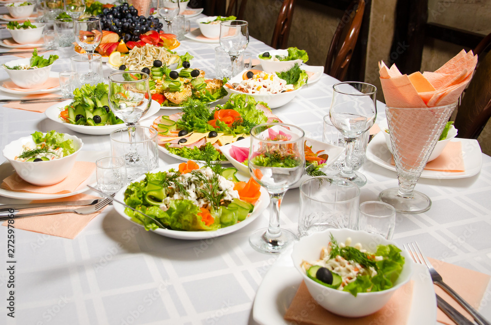 table lined with variety of dishes from which the centerpiece is dish with banquet cutting with ham and dish with several tartlets with chicken and ham