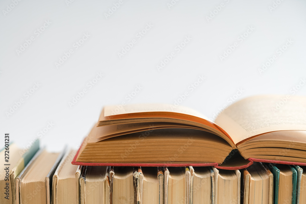 Naklejka premium Open book on white background, hardback books on wooden table. E