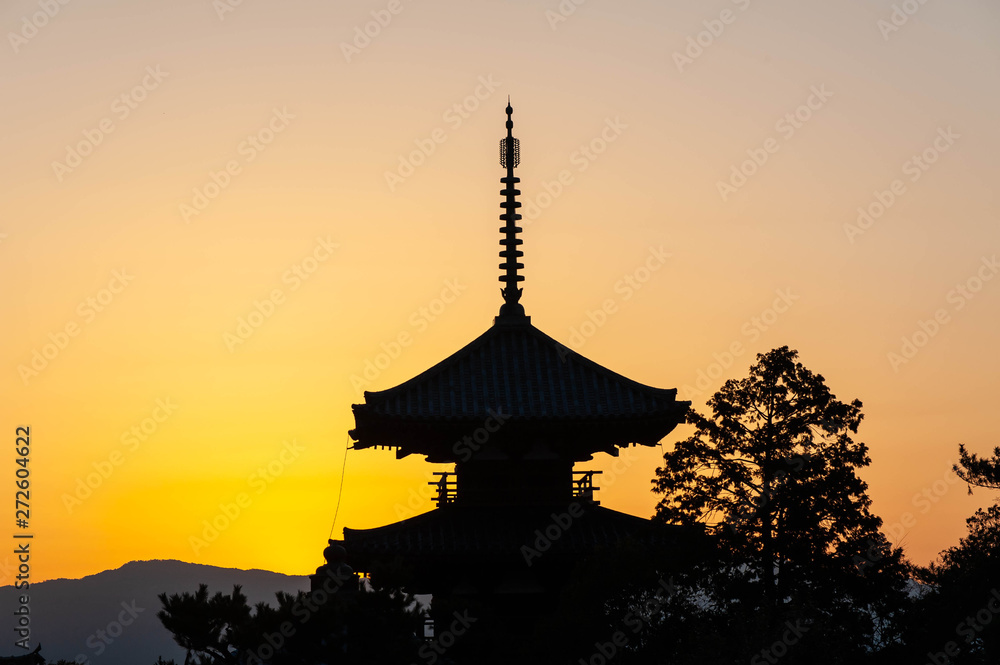 朝日が昇る塔と樹木