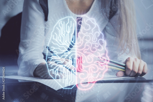 Multi exposure of woman's writing hand on background with brain hud. Concept of learning.