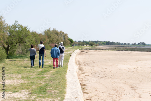senior parents with adult offspring children Walking On Beach coast