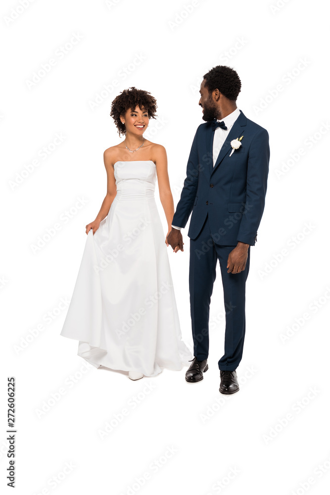 happy african american bridegroom holding hands with beautiful bride in wedding dress isolated on white happy african american bridegroom holding hands with beautiful bride in wedding dress isolated on white