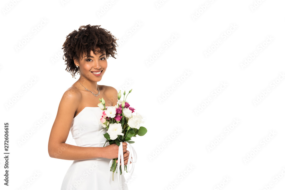 happy african american woman in wedding dress holding bouquet and looking at camera isolated on white happy african american woman in wedding dress holding bouquet and looking at camera isolated on white