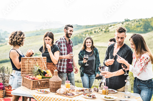 Canvas Print Happy adult friends eating at picnic lunch in italian vineyard outdoor - Young p