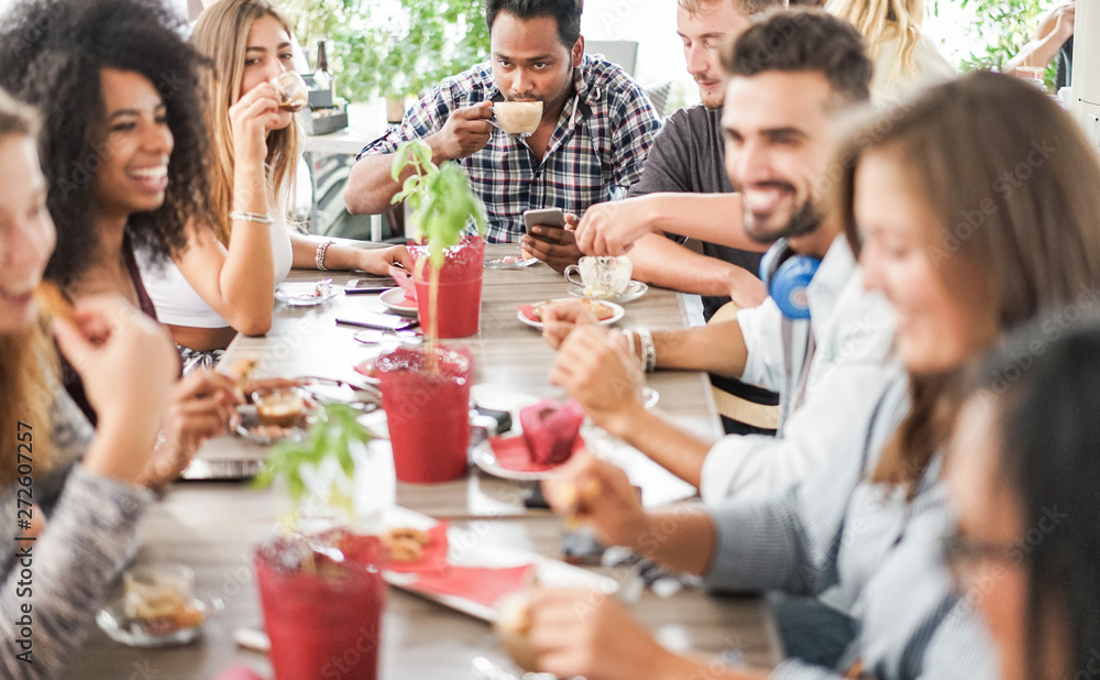 Group of happy friends drinking coffee and cappuccino at vintage bar - Young students people eating and talking at breakfast - Friendship, trend and food concept - Focus on indian guy face