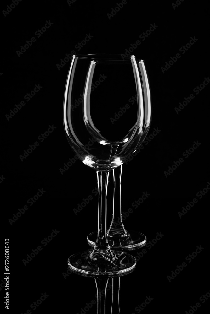 Two empty transparent wine glasses, isolated on black background Two empty transparent wine glasses, isolated on black background