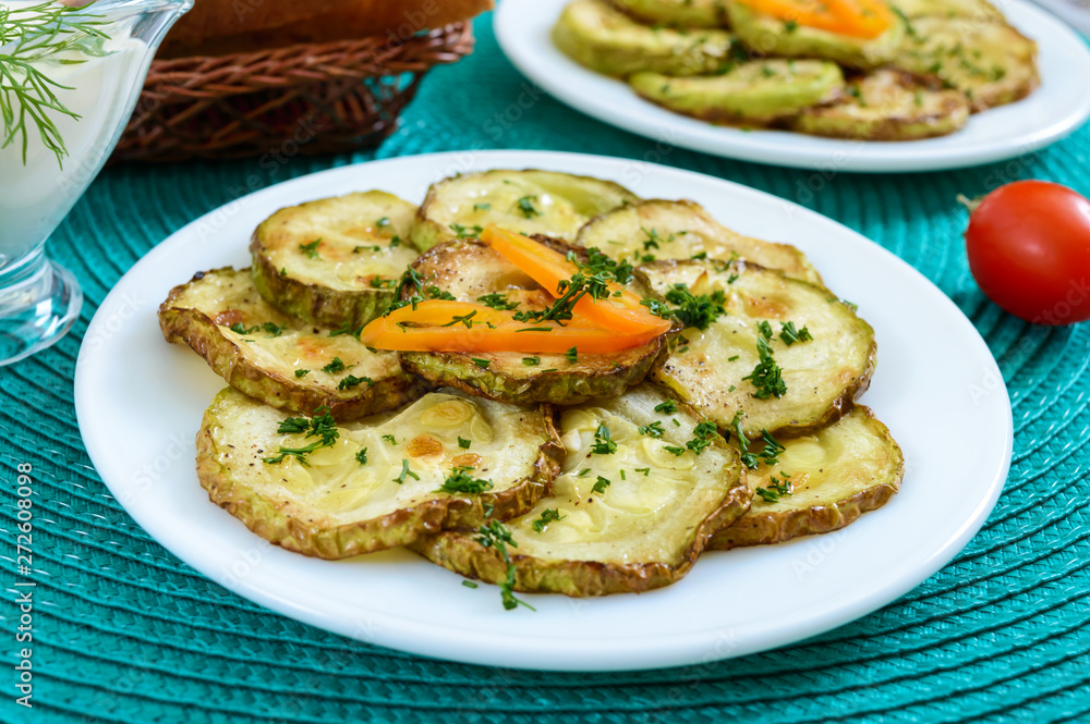 Tasty fried zucchini slices on a plate with sauce on a wooden table. Picnic snack. Rustic style