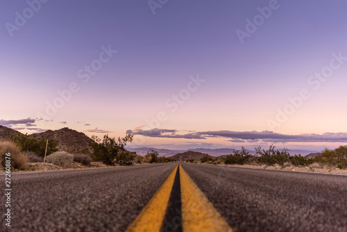 Travel around California! Empty night road with desert landscape around.