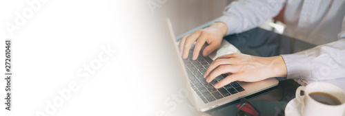 Cropped image of a young man working on his laptop, man hands busy using laptop at office desk. Young businessman working with laptop at office. Copy space