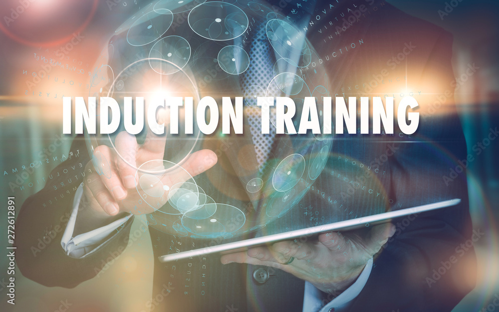 Fototapeta premium A hand selecting a Induction Training business concept on a futuristic computer display.