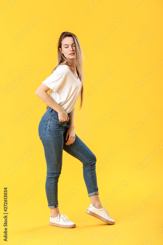 Stylish young woman in jeans on color background Stylish young woman in jeans on color background
