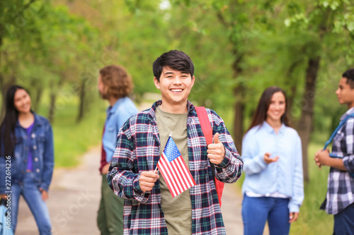 Asian student with USA flag outdoors