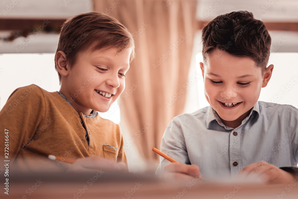 Two adopted children smiling broadly while communicating Two adopted children smiling broadly while communicating
