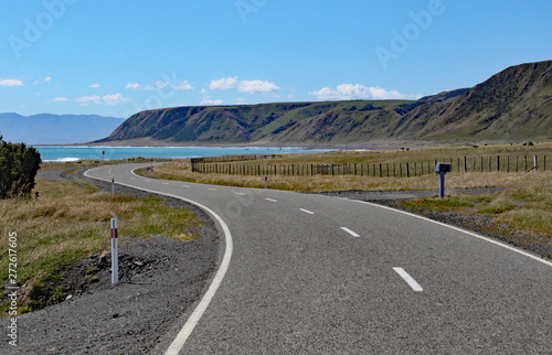 A deserted road winds towards the bay at Cape Palliser, North, Island, New Zealand photo